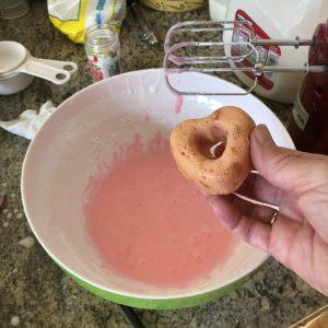 Dipping donuts into glaze
